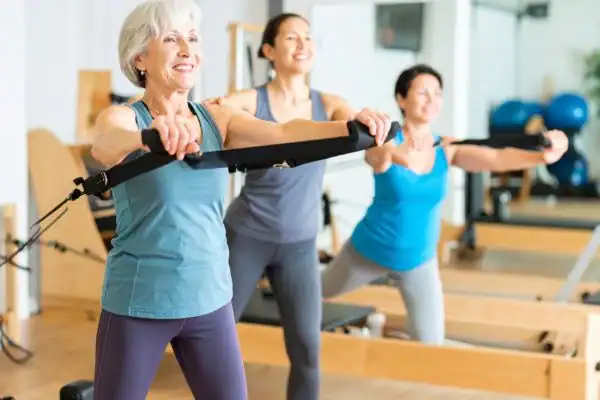 Toning Arms After 60: Empowering Womens Fitness Through Effective Weight Training 2 older woman doing weight training Herne Bay and resistance in the gym to tone upper arms