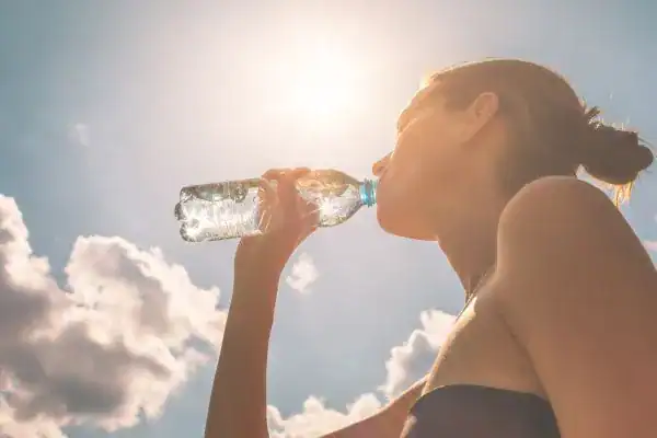 Hydration: The Secret Ingredient for a Toned Stomach and Enhanced Fitness 3 Image of woman drinking water to hydrate Herne Bay after run.